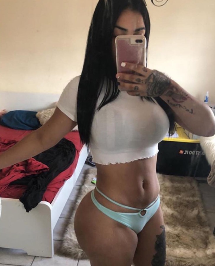 Mary Santos, a Puerto Rican OnlyFans model, taking a white-top mirror selfie