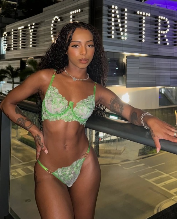 Ebony OnlyFans creator Bria Backwoods in green lace lingerie on a city-center balcony